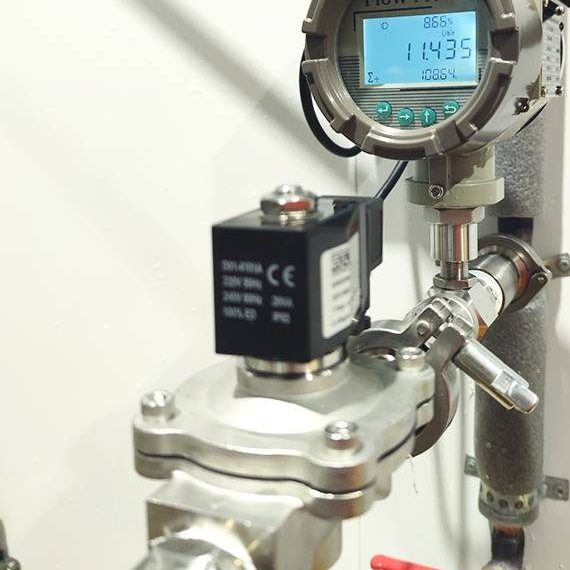 Flujómetro digital de acero inoxidable junto a una válvula solenoide