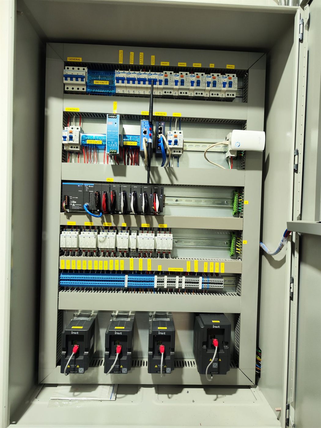 Tablero de control abierto con PLC, borneras rotuladas y variadores de frecuencia